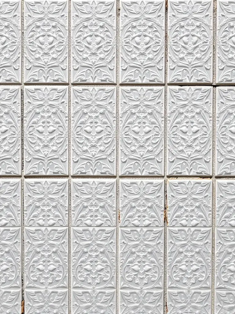 A beautifully designed custom-tiled wall in a spa bathroom, featuring intricate patterns and high-quality materials, installed by NML Bathroom Renovations.