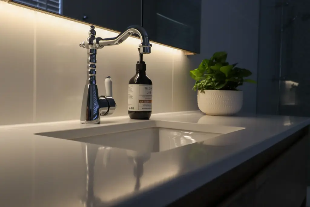 Angled close-up of a white basin, chrome tap and timber vanity.