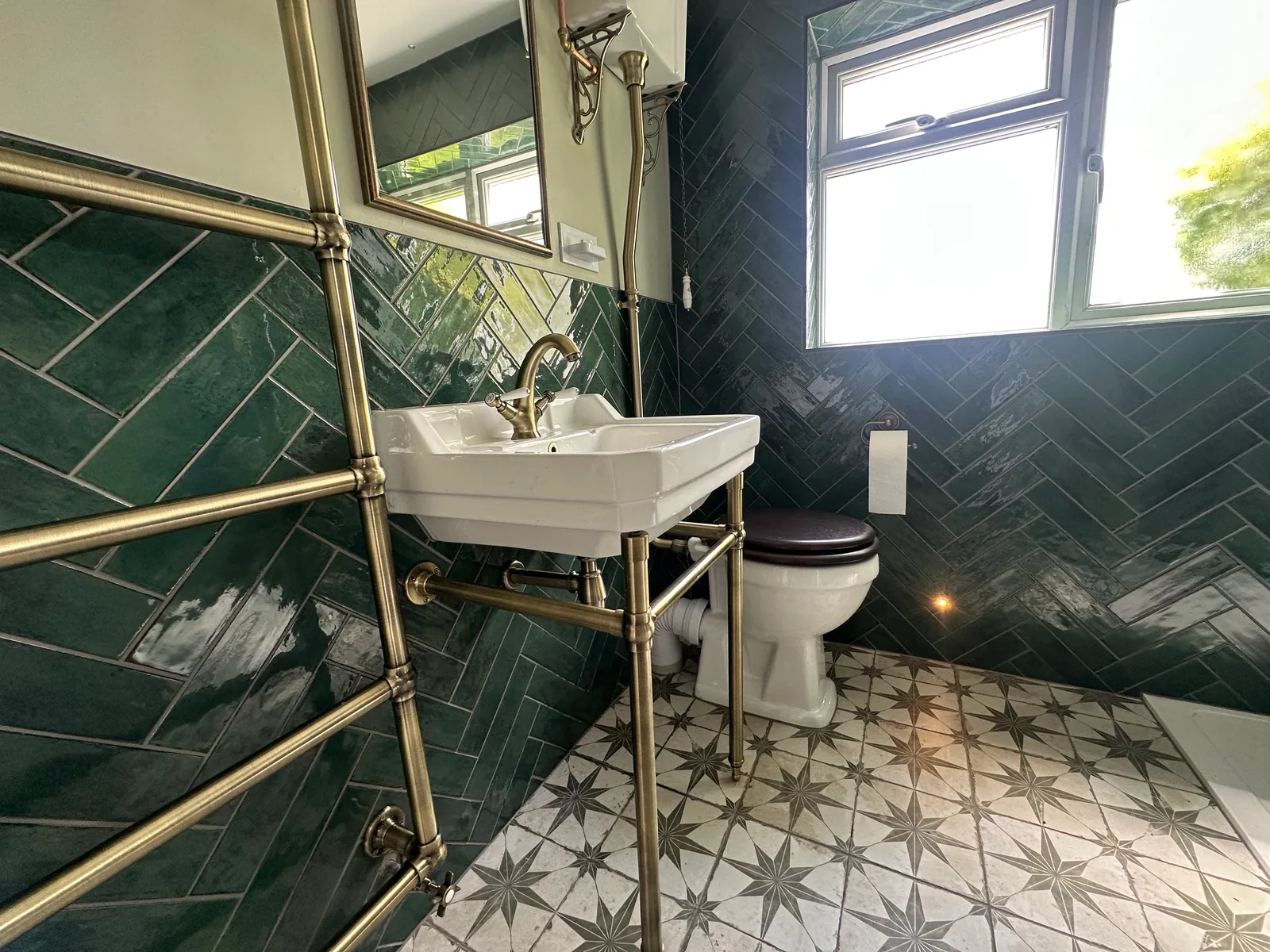 Star-patterned floor tiles beside the basin and towel rail in the Bishops Cleeve shower room.