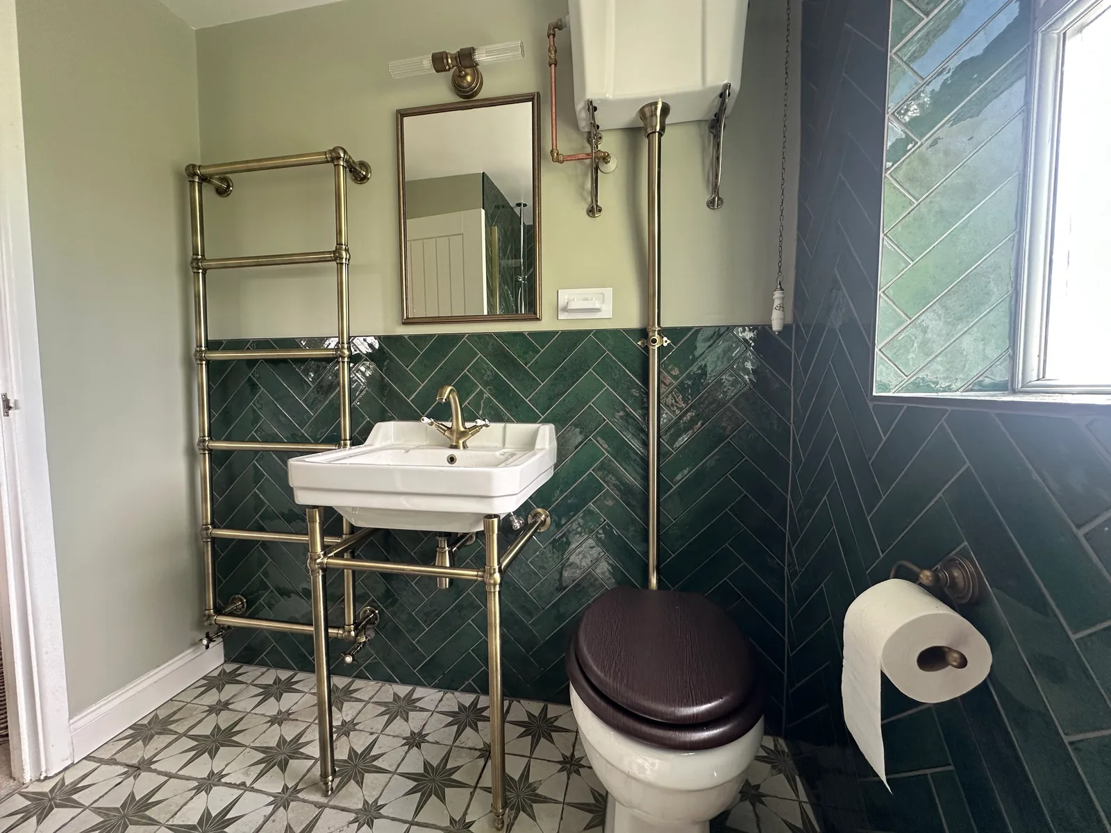Traditional-style toilet with a dark seat, basin and high-level cistern in Bishops Cleeve.