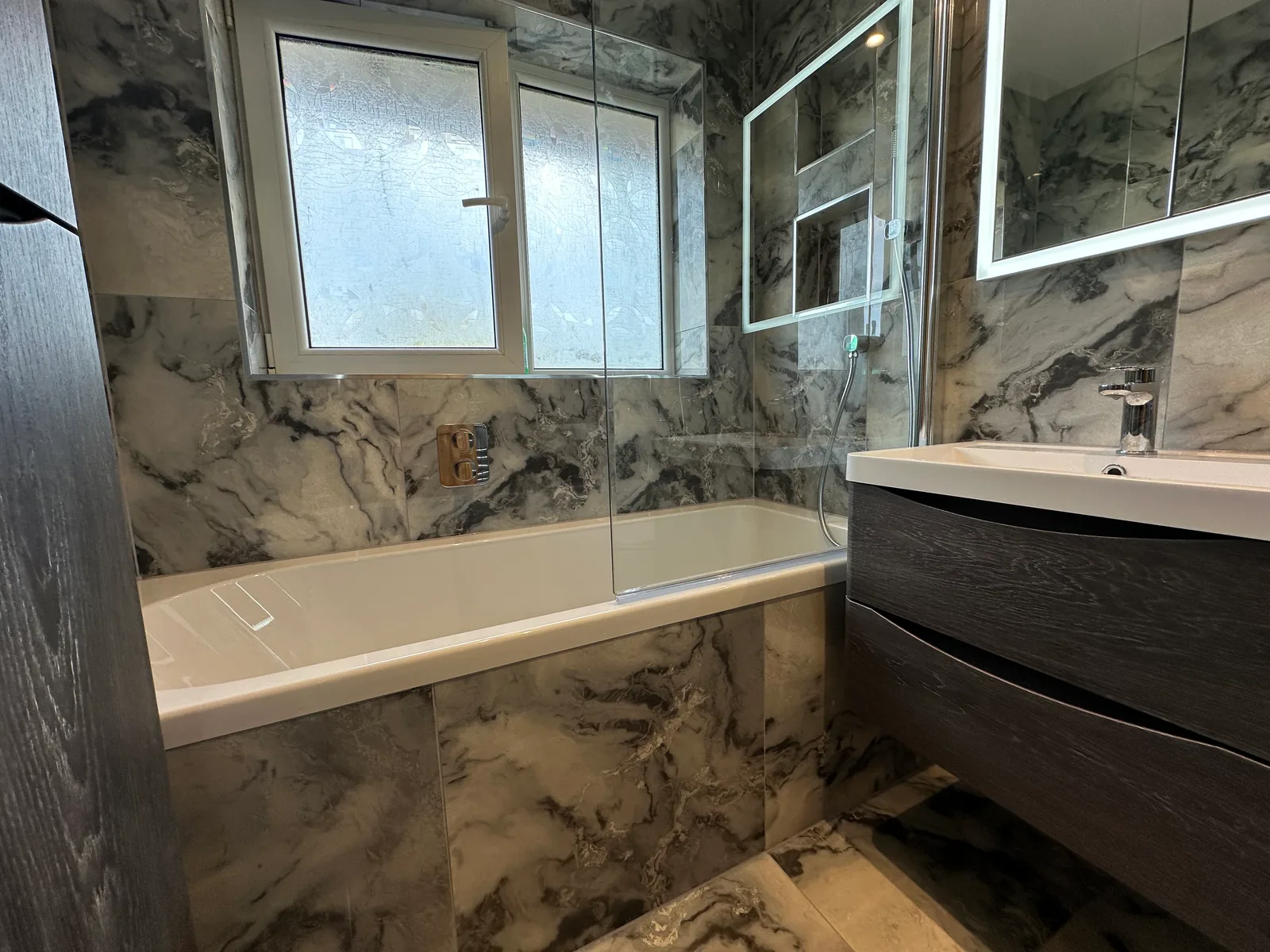 Bath And Shower Screen Beside Marble-Effect Tiles In The Evesham Bathroom