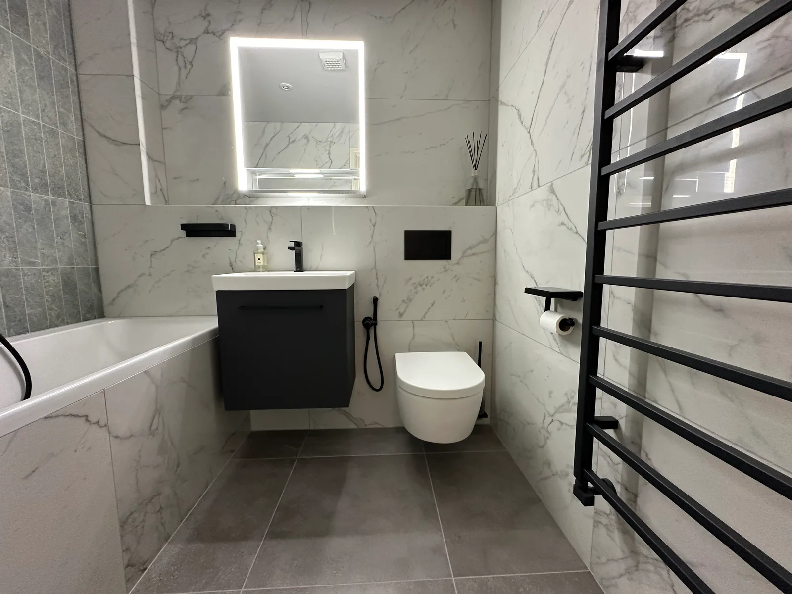 Two complete bathroom renovations in Tuffley, Gloucester 6 Dark Vanity, Illuminated Mirror And Black Ladder Towel Rail In The First Tuffley Bathroom.