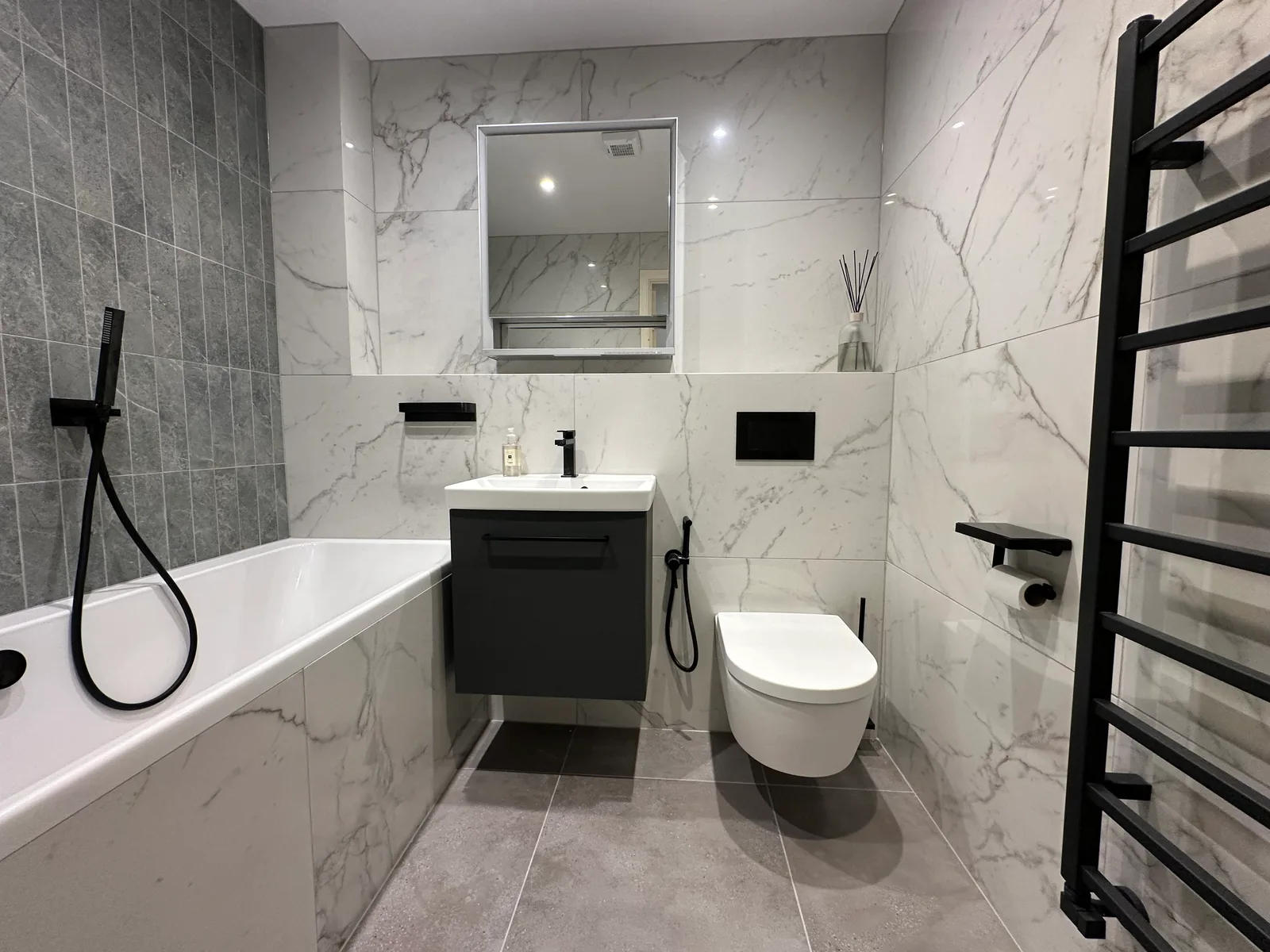 Two complete bathroom renovations in Tuffley, Gloucester 4 Dark Vanity, Wall-Hung Toilet And Grey Tiled Floor In The First Tuffley Bathroom.