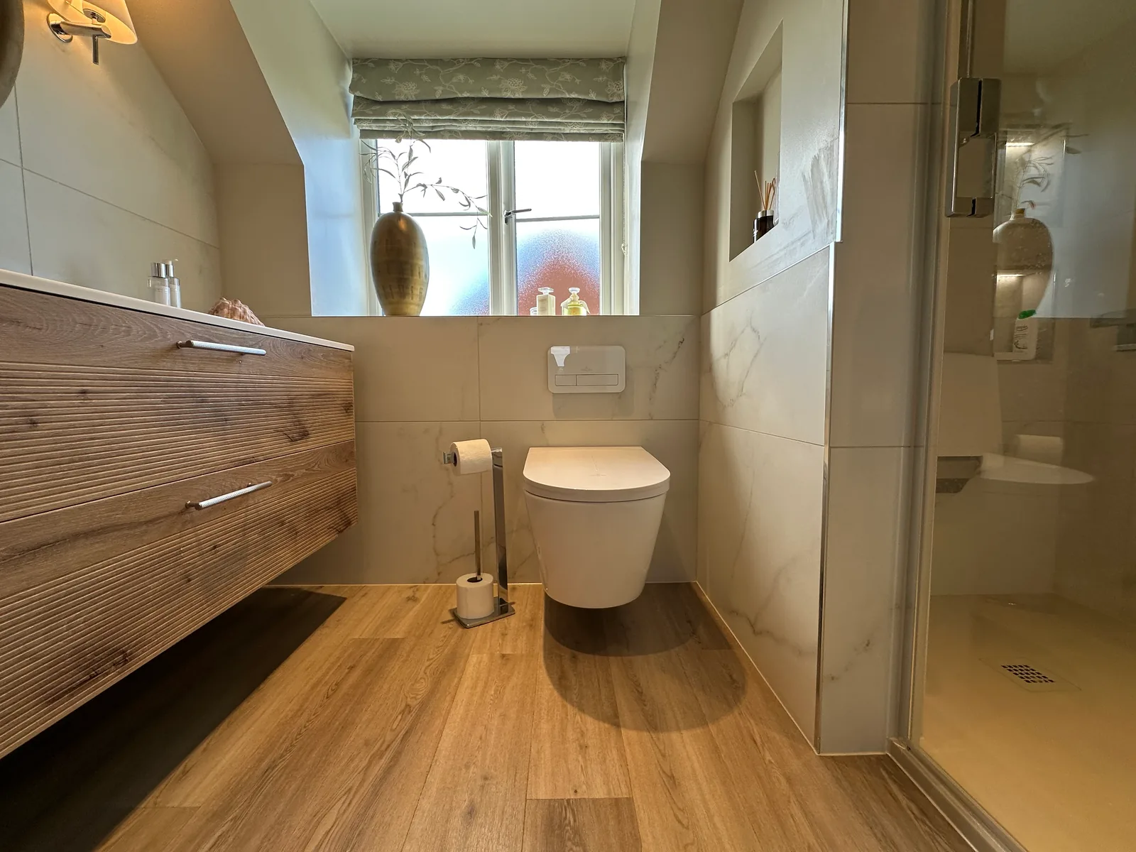 Wood-effect flooring, wall-hung toilet and vanity in Christine’s Twyning bathroom